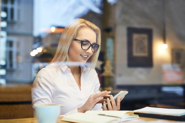 istock Young business woman using her smartphone at cafe during coffee break 888710318