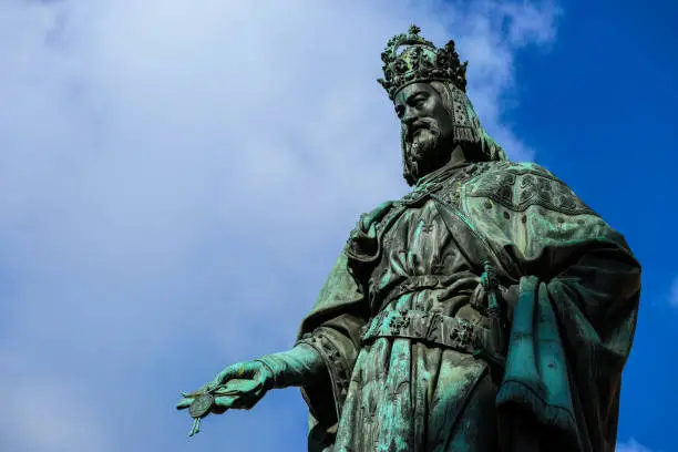 Photo of Statue of King Charles, Prague, on a blue sky background.