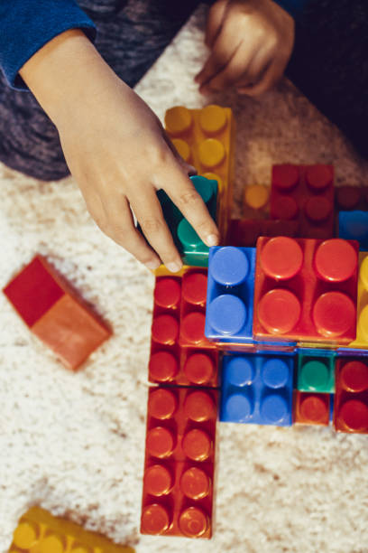 istock Child playing with toy blocks on the carpet. 888723314