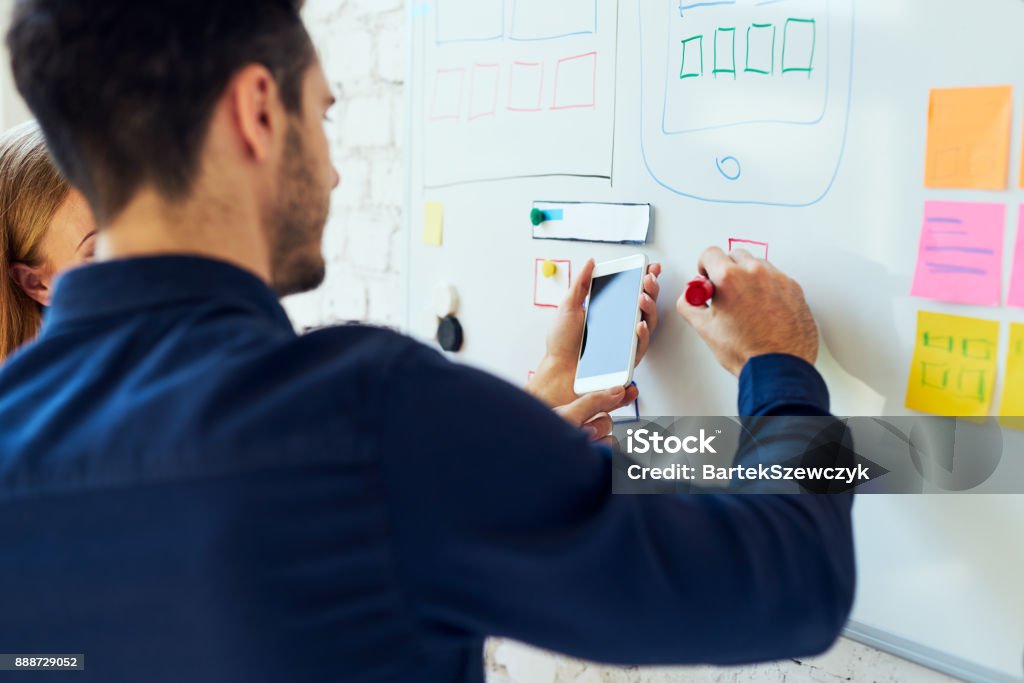 Closeup of ux designers prototyping mobile application layout Whiteboard - Visual Aid Stock Photo