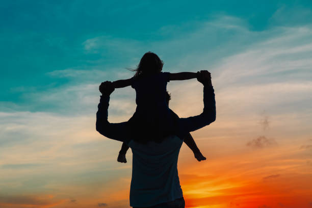 istock Father and little daughter silhouettes play at sunset 888736268