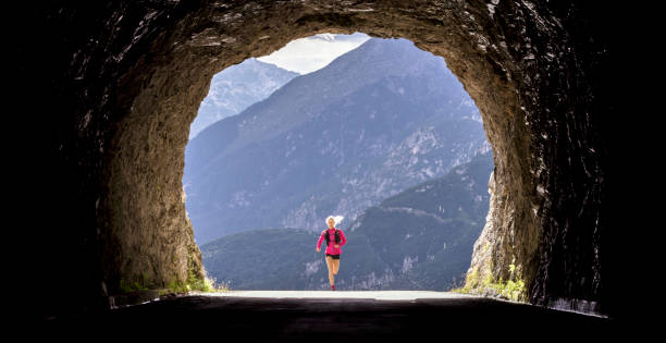 istock Female athlete running through tunnel high in mountains 888739440