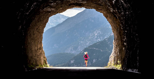 istock Female athlete running through tunnel high in mountains 888739444