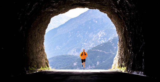 istock Male athlete running through tunnel high in mountains 888739718