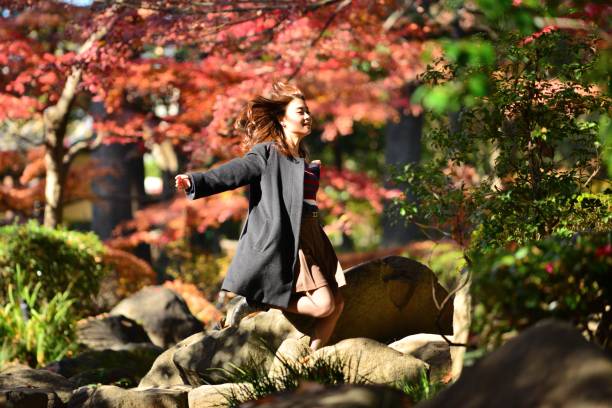 jovem mulher japonesa anda pisando pedras riacho, tóquio - footpath tree japan stepping stone - fotografias e filmes do acervo