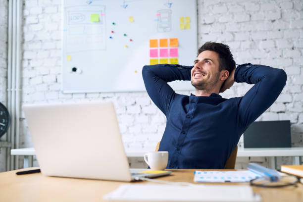 istock Smiling handsome businessman relaxing and enjoying coffee while taking break from work in office 888740138