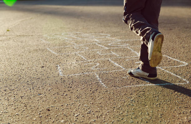 istock little boy playing hopscotch on playground 888740264
