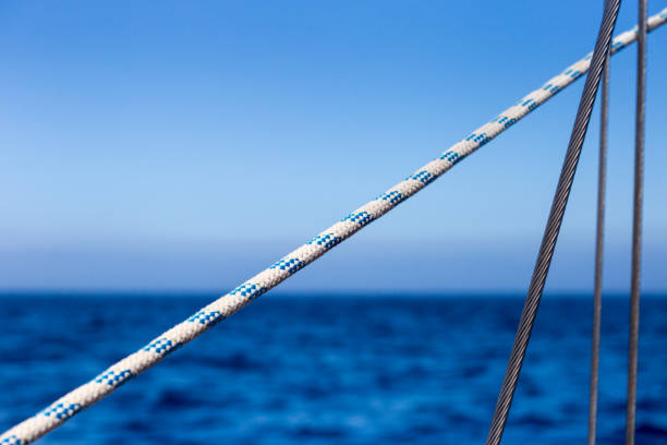 istock Sailing Ropes in Front of bight blue Ocean and Sky Background 888755142