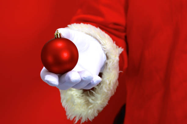 istock Santa Claus hand presenting your christmas text or product over red background with copy space 888756536