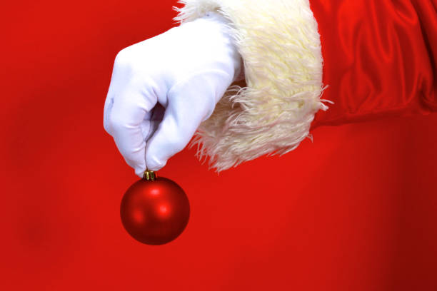 istock Santa Claus hand presenting your christmas text or product over red background with copy space 888756796