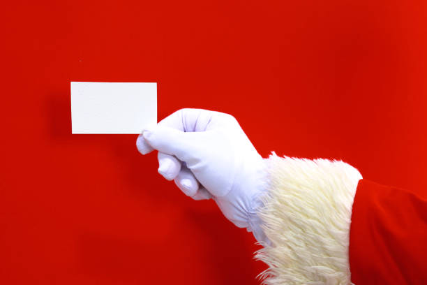 istock Santa Claus hand presenting your christmas text or product over red background with copy space 888759742