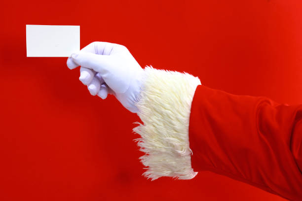 istock Santa Claus hand presenting your christmas text or product over red background with copy space 888759936