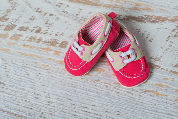 istock Baby red shoes on a rope against a white brick wall 888759946