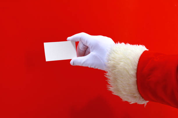 istock Santa Claus hand presenting your christmas text or product over red background with copy space 888760418