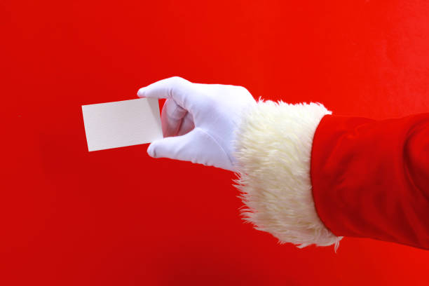 istock Santa Claus hand presenting your christmas text or product over red background with copy space 888760762