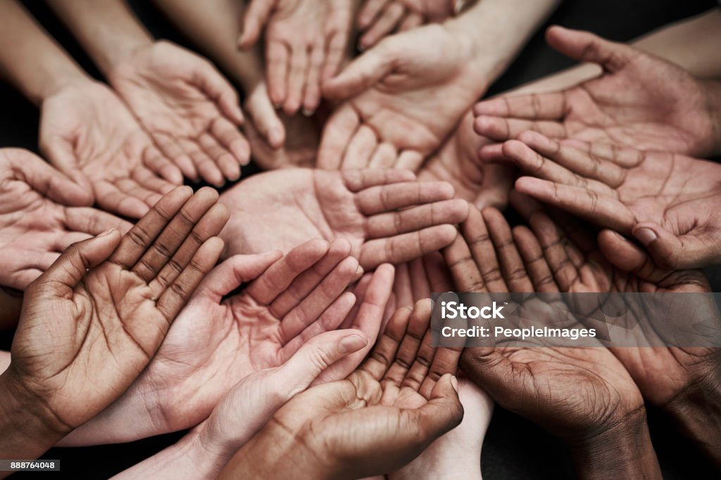 We can’t help everyone, but everyone can help someone Shot of a group of hands held cupped out together Humanitarian Aid Stock Photo