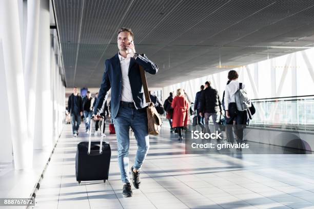 Busy Man Speaking On Phone And Walking In Airport Stock Photo - Download Image Now - Airport, Urgency, Busy