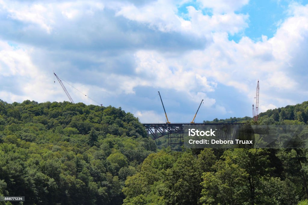 Cranes on the railroad bridge at Letchworth State Park Four cranes on the bridge, forest around the bridge and blue cloudl sky in the background Blue Stock Photo