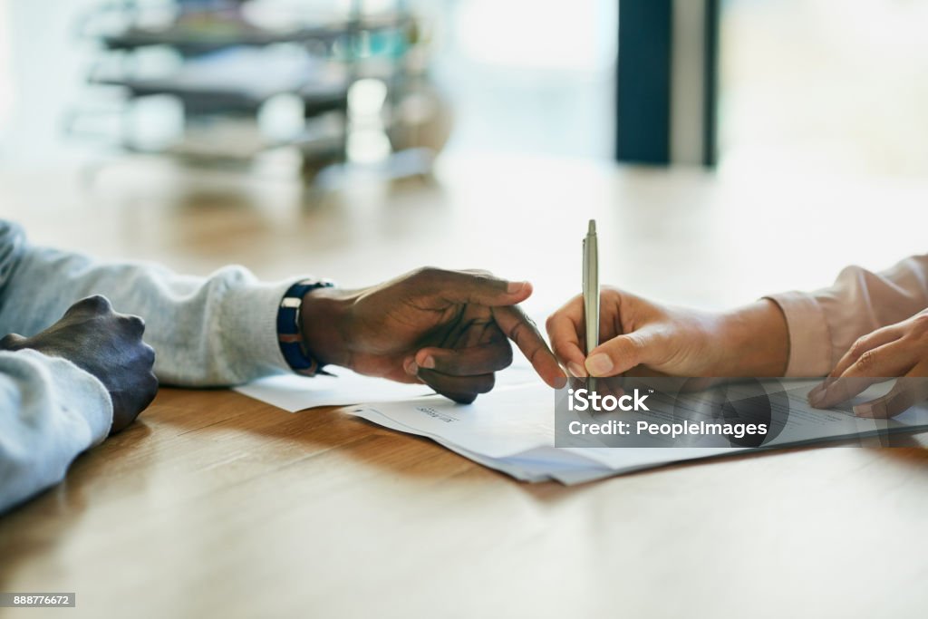Running over the terms and conditions in her contract Closeup shot of two businesspeople filling in paperwork in an office Contract Stock Photo