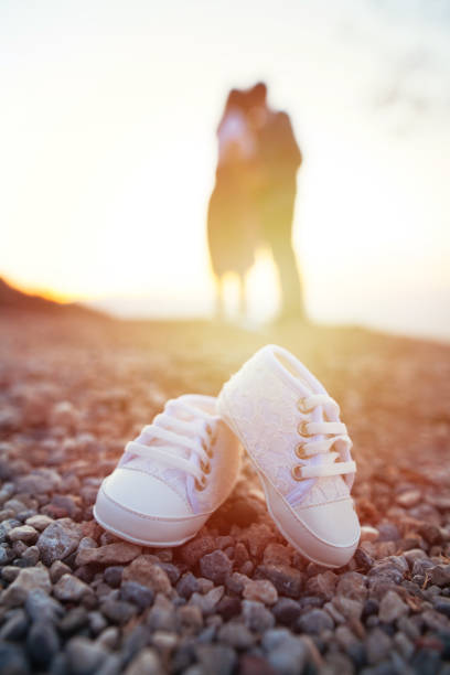 zukünftige mutter und vater füße mit kleinen baby-schuh - pair cheerful happiness heterosexual couple stock-fotos und bilder