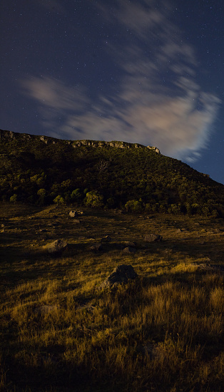 Illuminated clouds from the full moon rises over landscape in New Zealand.