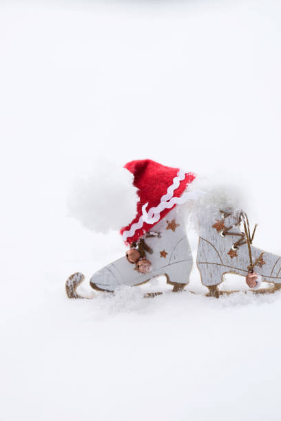 Winter holidays background:  wooden made skates and Santa Claus hat. Closeup