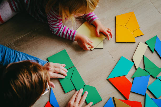 istock teacher and child playing with geometric shapes 888877698