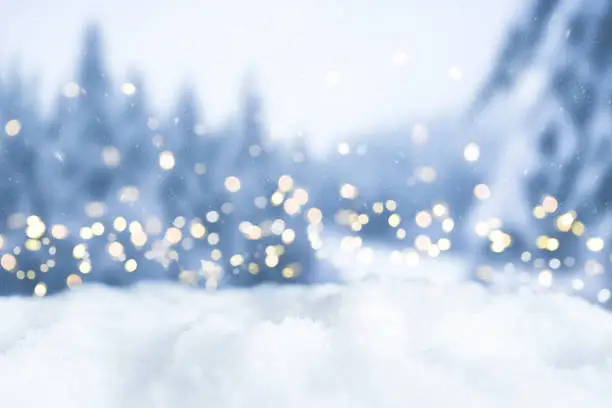 Photo of snowy winter christmas bokeh background with circular lights and trees