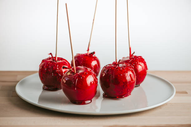 Candied apples on stick on plate.