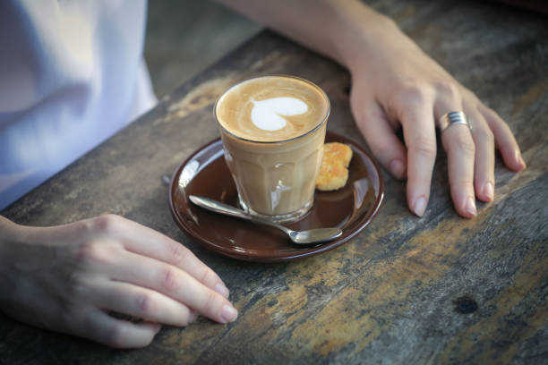 Coffee time. Close up image of girl holding spoon and a cup of coffee