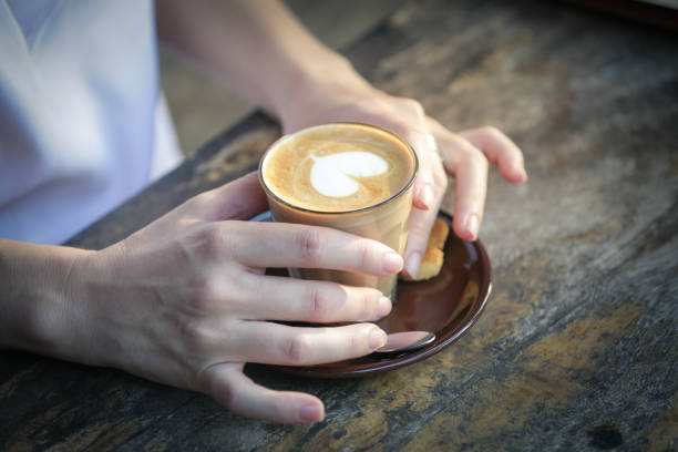 Coffee time. Close up image of girl holding spoon and a cup of coffee