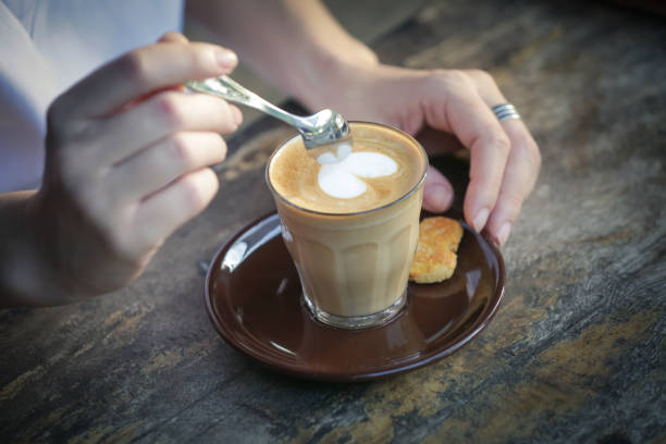 Coffee time. Close up image of girl holding spoon and a cup of coffee