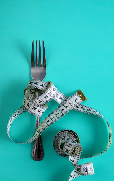 istock Fork with measuring tape. Dieting concept. On blue. 888900232