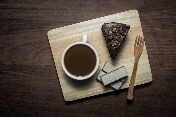 A cup of instant coffee and a slice of  homemade chocolate cake on old cloth napkin