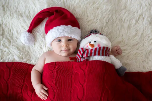 Photo of Christmas portrait of cute little newborn baby boy, wearing santa hat
