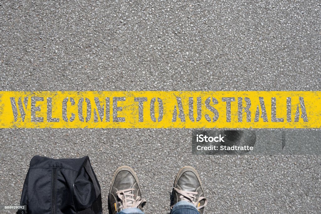 A man with a suitcase stands on the border with Australia A man with a suitcase stands at the border with Australia Emigration and Immigration Stock Photo