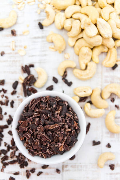 cocoa nibs and cashews on wooden background