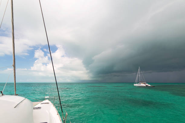 Tropical weather storm passes over two sailboats in an island anchorage