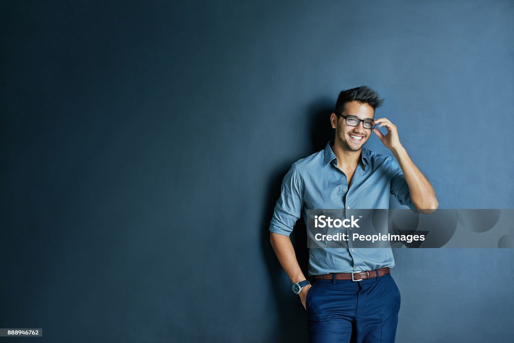 He will see you later Studio shot of cheerful young man with glasses standing with one hand in his pocket while looking at the camera Men Stock Photo