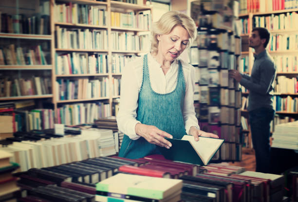 istock Woman reading book in book shop 888961384