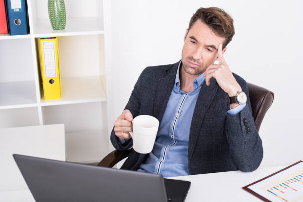 istock Businessman with a cup of coffee concentrating on the work 888974584