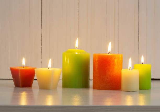 istock orange, green and white  candles on white background 888977802