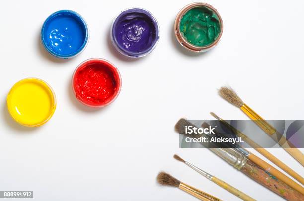 Paints In Jars And A Brush On A White Sheet Of Paper Top View Stock Photo - Download Image Now
