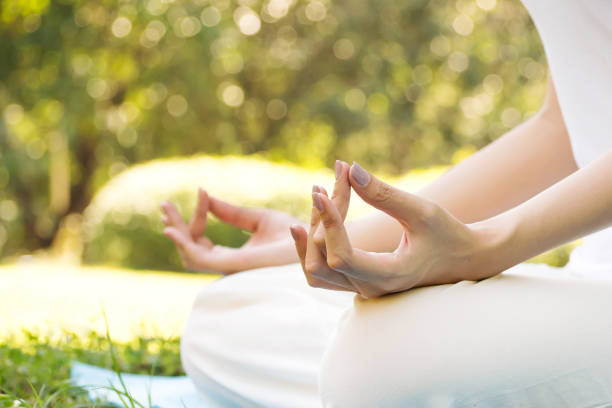 istock Young Asian woman practicing meditation in park. Closeup hands with copy space. Good activity for health and mind. 888999392