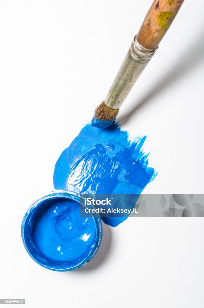 paints in jars and a brush on a white sheet of paper, top view No People Stock Photo