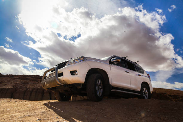 Ait Saoun, Morocco - February 23, 2016: Backdrop view of a 4x4 vehicle without driver in the Moroccan desert under a beautiful sunset in the background and a sifted evening light