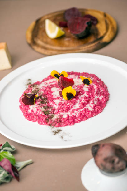 chef professionista che prepara il pasto in casa privata: risotto alla barbabietola rossa con fonduta di formaggio taleggio e tè affumicato lapsang souchong - lapsang souchong tea foto e immagini stock