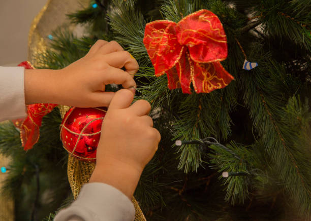 istock close up child hanging Christmas decoration- 889008716