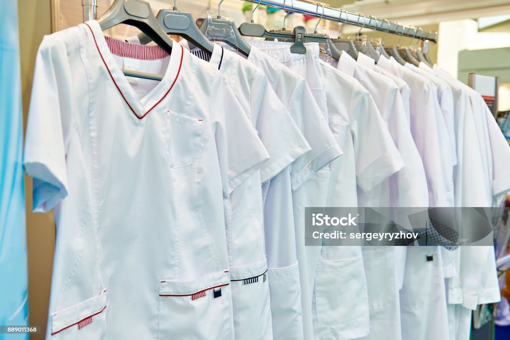 Medical gowns for nurses on hanger in store Medical gowns for nurses on a hanger in a store Uniform Stock Photo