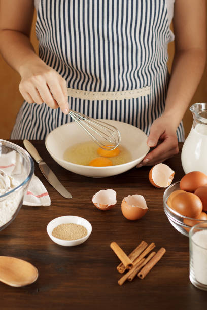 istock Woman mixing eggs in the bowl for pastry recipe on kitchen table. 889015594